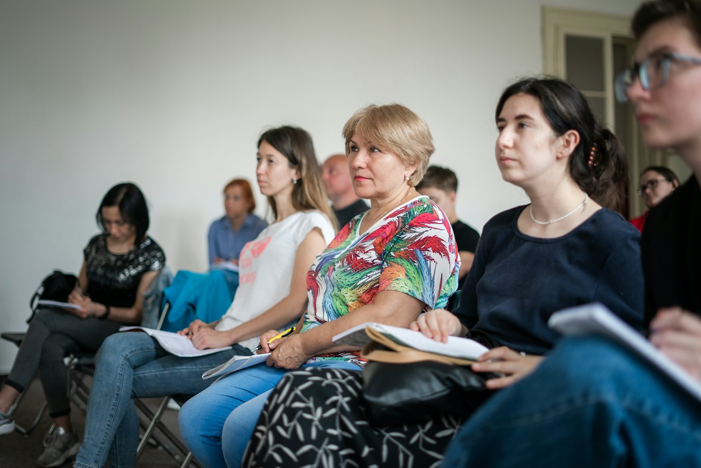 Adults attending a class and taking notes.